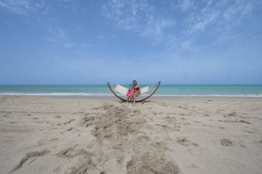 Kız, plajda bir hamakta dinleniyor.