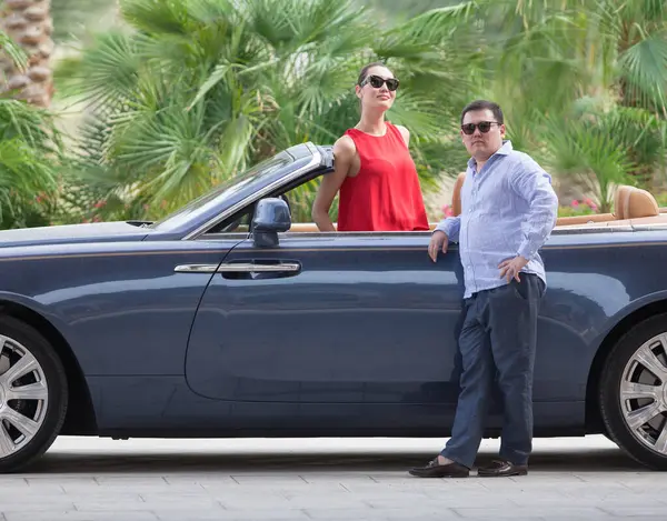 a rich woman and a man in a cabriolet