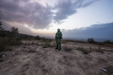 Kirlenmiş bir şehirde gaz maskeli bir adam.