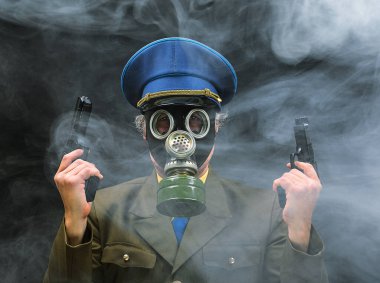 Siyah arka planda silahlı, gaz maskeli bir askerin portresi.