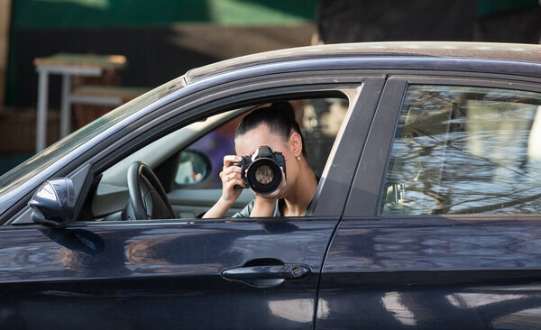 beautiful paparazzi girl with a camera in the car