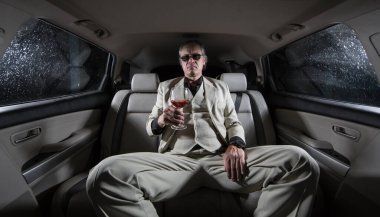 Beyaz takım elbiseli adam silahlı, çete üyesi, arabada mafya.