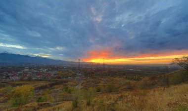 Şehrin üzerinde gün batımı, büyük bir güneş, Kazakistan, Almaty