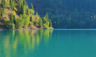 Bir dağ gölünün su yüzeyi, sulara yansıyan dağlar.