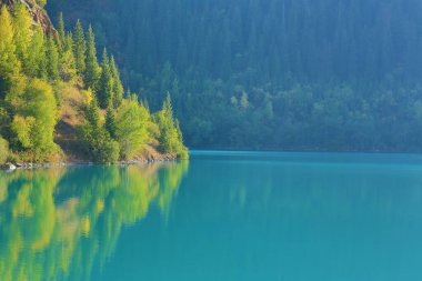 Bir dağ gölünün su yüzeyi, suya yansıyan dağlar, su turkuvazı.
