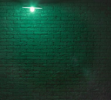 Siyah tuğladan bir odada yeşil avize lambası