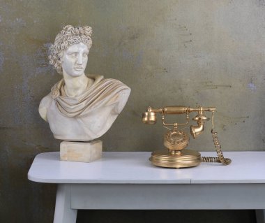 Masasında eski bir altın telefon olan eski bir oda.