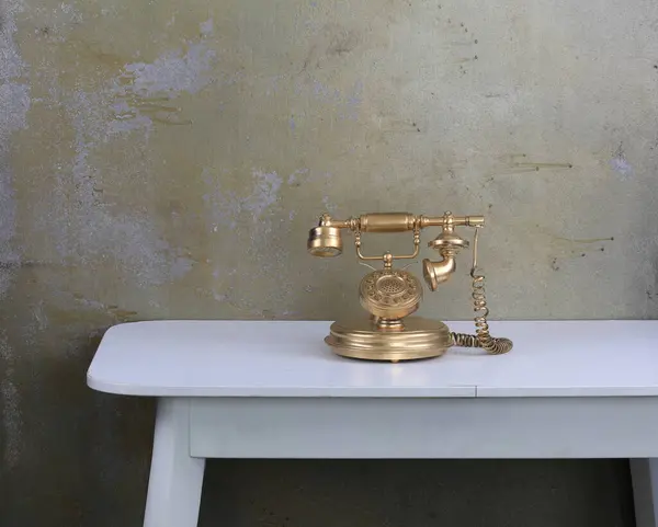 old room with an old gold telephone on the table