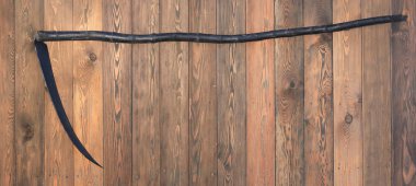 Cadılar Bayramı tırpanı ahşap arka planda