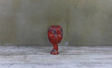  Tahta bir masada kırmızı tahta Afrika maskesi.