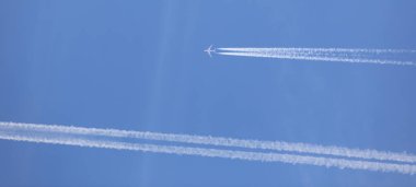 two double airplane tracks in the blue sky