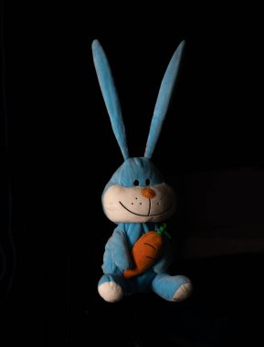 yumuşak peluş tavşan oyuncağı, uzun kulaklı, siyah arka planda izole edilmiş.