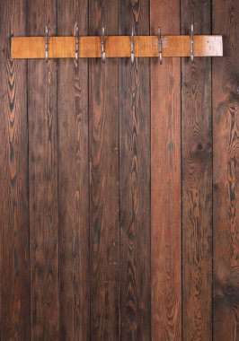 Eski ahşap duvarda kancaları olan ahşap askılar.