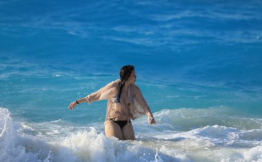 Kız deniz dalgalarında yüzüyor.