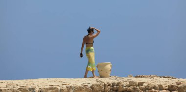  Mayolu güzel esmer kadın deniz kıyısında dinleniyor.