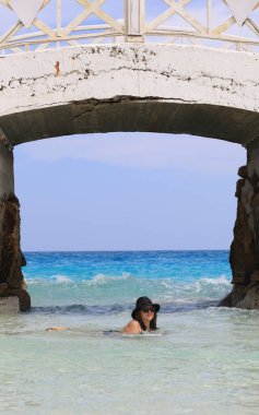 Mayolu yetişkin bir kadın deniz kıyısında dinleniyor.