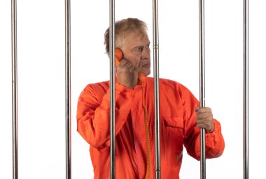 Elleri kelepçeli turuncu cüppeli bir adamın portresi.