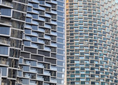 Pencereleri ve yansımaları olan gökdelen arkaplanı