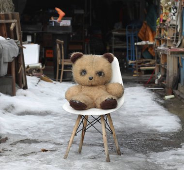  Dışarıdaki sandalyedeki eski kirli oyuncak ayı.