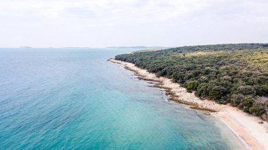 Rovinj yakınlarındaki Cisterna Sahili 'nde mavi denizli Rocky plajı.