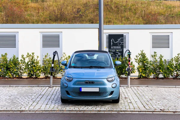 Almanya, Zusmarshausen 26.11.2022; Sortimo otobanı üzerindeki şarj parkında mavi bir Fiat 500e