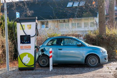 Germany, Dieen, 06.01.2023, A blue Fiat 500 electric convertible with black roof is charging at a Energie South bavaria charging station 