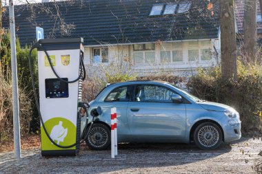 Germany, Dieen, 06.01.2023, A blue Fiat 500 electric convertible with black roof is charging at a charging station 