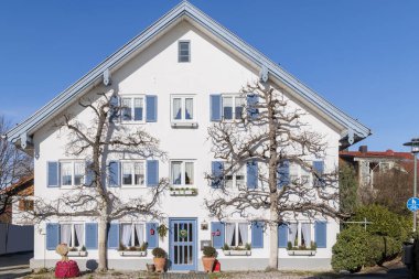Festively decorated house with two espalier fruit trees under a blue sky in Dieen am Ammersee 
