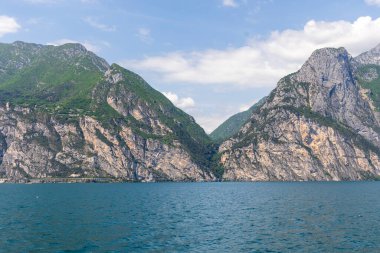 Wooded mountain top and rock wall on the northern shore of Lake Garda in Italy