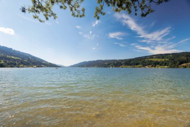 View over the Alpsee near Immenstadt to the opposite shore with mountains and forests