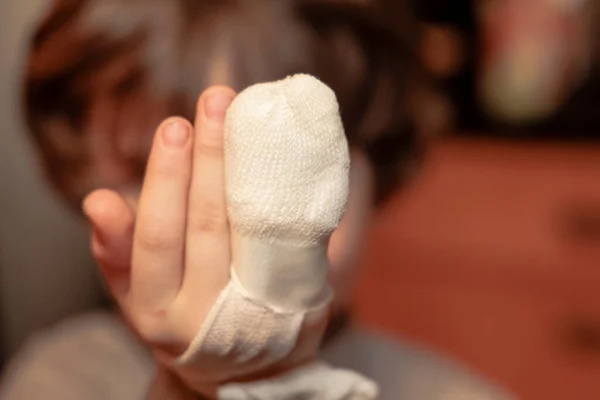 Child hand with finger bandage after injury