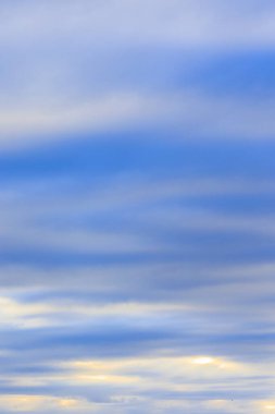 Güneş ışınları, kışın bulutlu bir günde Baden-Wrtemberg 'de Ravensburg yakınlarındaki ormanlık bir arazide yoğun bir bulut örtüsünü delip geçer..