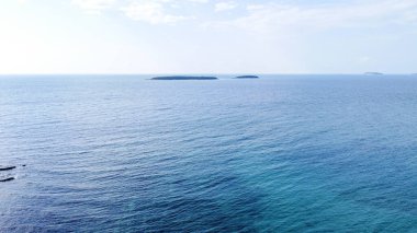Rovinj yakınlarındaki Cisterna Sahili 'nde mavi denizli Rocky plajı.
