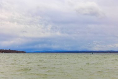 Bulutlu bir günde Ammersee 'ye bak.