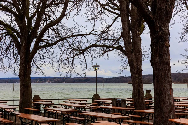 An empty beer garden in the winter break on a windy rainy day with cloudy sky in Stegen am Ammersee