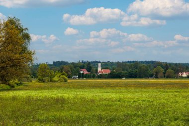Augsburg yakınlarındaki Schmutter Vadisi 'nde yeşil çayırları ve sarı tecavüz tarlaları olan Hilly manzarası