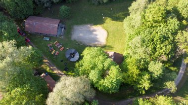 Göl kenarındaki ağaçların arasından yurt çadırlarını kurarken yukarıdan izci kampına bak.