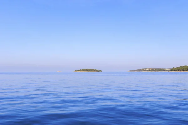 在阳光灿烂的日子里 克罗地亚罗维尼附近有三个平坦的岛屿 蓝天在海面上 — 图库照片
