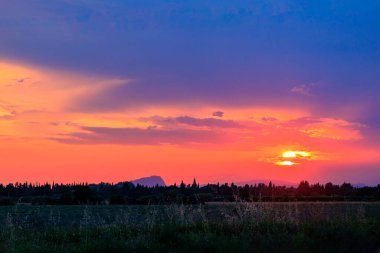 Aigues-Mortes yakınlarındaki Camarque tarlalarının üzerinde güzel bir günbatımı.
