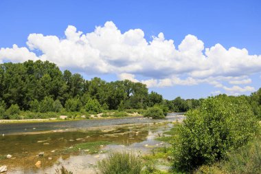 Fransa 'daki Gardon nehri Pont-du Gard yakınlarında mavi gökyüzü ve kümülüs bulutlarıyla dolu bir yaz günü