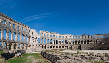 Hırvatistan 'ın Pula kentindeki Roma arenasının kalıntıları güneşli bir günde mavi bir gökyüzünün altında