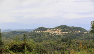 Korfu adasının kuzeyindeki dağ köyü. Ormanlık dağlar ve zeytin tarlaları arasında.