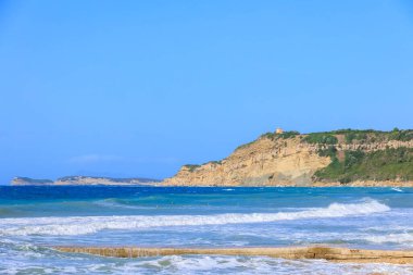 Korfu adasının kıyıları Arillas kasabası yakınlarında mavi gökyüzü ve ağır denizlerin altında