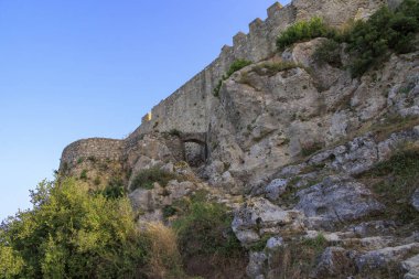 Akşam vakti, Korfu adasındaki mavi gökyüzünün altında Angelokastro Kalesi harabeleri.