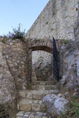 Akşam vakti, Korfu adasındaki mavi gökyüzünün altında Angelokastro Kalesi harabeleri.