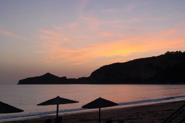 Denizin üzerinde gün batımı ve Korfu adasındaki Agios Georgios Körfezi.