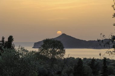 Denizin üzerinde gün batımı ve Korfu adasındaki Agios Georgios Körfezi.