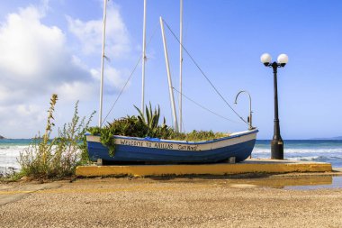 Eski ekilmiş bir yelkenli, Korfu adasında mavi bir gökyüzüne karşı İngiliz yazıtlarıyla Arillas 'a hoş geldiniz, Yunanistan, Arillas, 22.10.2023