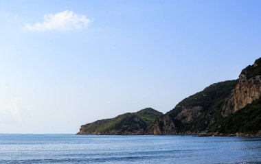 Agios Georgios yakınlarındaki kumsalda Korfu adasında mavi gökyüzünün altında