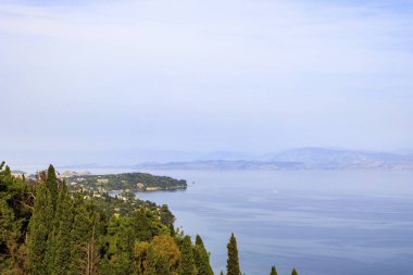 İmparatoriçe Sissi Achilleion 'un eski villasından Corfu şehrine kadar uzanan selvi ve zeytin ağaçlarının manzarasına bakın.